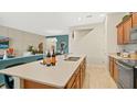 Modern kitchen featuring stainless steel appliances, wood cabinets, a large island with a sink, and wood floors at 2345 White Buffalo St, Apopka, FL 32703