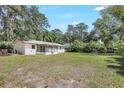 A large backyard with mature trees and a screened-in porch, perfect for outdoor activities and relaxation at 2536 Nw 3Rd Ave, Ocala, FL 34475