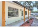A view of the front porch with wood columns, newly planted landscaping, and a white front door with gray trim at 2536 Nw 3Rd Ave, Ocala, FL 34475