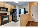 Well-lit kitchen with wood cabinets, black appliances, and contrasting countertops at 2935 Greenwood Springs Loop, Lake Mary, FL 32746