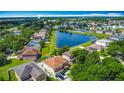 Stunning aerial view of homes surrounding a scenic pond, with blue skies above at 3234 Amberley Park Cir, Kissimmee, FL 34743
