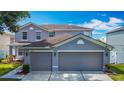 Attractive two-story gray home with a three-car garage and well-maintained landscaping at 3234 Amberley Park Cir, Kissimmee, FL 34743