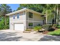 Two-story home with a two-car garage, neutral paint and well-maintained landscaping on a concrete driveway at 33925 Highland Rd, Leesburg, FL 34788