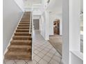 Bright entryway boasts high ceilings, tile flooring, and a carpeted staircase at 4785 Cumbrian Lakes Dr, Kissimmee, FL 34746