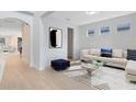 Staged living room with modern decor, hardwood floors, and ample natural light from the adjacent windows at 5116 Sorrento W Blvd, St Cloud, FL 34771