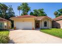 Charming single-story home with a red tile roof, well-manicured lawn, and a two-car garage at 602 Nighthawk Cir, Winter Springs, FL 32708