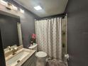 The bathroom features a modern vanity, toilet, and a shower with a colorful polka dot curtain at 6436 Fig Leaf St, Magnolia Square, FL 34771