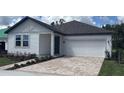 Charming single-story home with a brick driveway and well-maintained landscaping at 706 Junonia Blvd, New Smyrna Beach, FL 32168