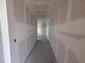 Unfinished hallway with freshly installed drywall ready for customization, showcasing a spacious layout at 706 Junonia Blvd, New Smyrna Beach, FL 32168