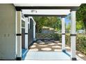 View of the front porch with stone step tiles, green landscape, and dark painted accents at 7712 Hoosier Pl, Orlando, FL 32807
