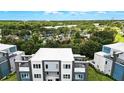 Community aerial view of modern townhouses near resort-style pool and clubhouse, surrounded by lush greenery at 7770 Sandy Ridge Dr # 234, Reunion, FL 34747