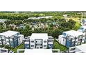 Community aerial view of modern townhouses near resort-style pool and clubhouse, surrounded by lush greenery at 7770 Sandy Ridge Dr # 234, Reunion, FL 34747