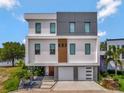 Modern three-story home with a two-car garage, manicured landscaping, and stylish design at 8157 Elion St, Orlando, FL 32827