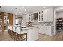 Bright kitchen with a large island, pendant lighting, and stylish white cabinets with glass fronts at 940 Club Cresswind Dr, Lady Lake, FL 32159