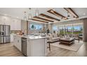 Open-concept living area with a kitchen island, wood beam ceiling, and a comfortable seating area at 940 Club Cresswind Dr, Lady Lake, FL 32159