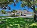 Charming exterior view of home with landscaped lawn, and a screened-in pool at 100 Demens St, Oakland, FL 34760