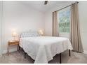Cozy bedroom with carpet flooring, a comfortable bed, neutral walls, and a view to the outside at 1073 River Otter Way, Deland, FL 32720