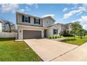 Two-story home featuring a gray exterior, well-manicured lawn, and attached two-car garage at 1073 River Otter Way, Deland, FL 32720