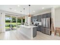 Modern kitchen with gray cabinets, stainless steel appliances, and center island with barstool seating at 1073 River Otter Way, Deland, FL 32720