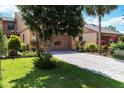 Charming home with a brick driveway, well-manicured lawn, and lush landscaping at 1085 Island Way, Leesburg, FL 34748