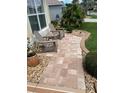 Inviting front porch with two Adirondack chairs on a paved walkway surrounded by lush landscaping at 1121 Alcove Loop, The Villages, FL 32162