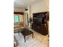 Comfortable living room with a plush sofa, a large TV, and a decorative coffee table at 1121 Alcove Loop, The Villages, FL 32162