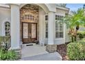 Inviting front entrance with decorative glass doors, stone accents, and manicured landscaping at 1158 Sweet Heather Ln, Apopka, FL 32712