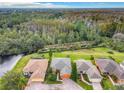 An aerial view of homes with lush green spaces, bordering a dense forest and waterways for privacy at 118 Ventana Dr, Poinciana, FL 34759
