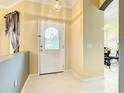 Bright entryway features a decorative glass front door, white tile flooring, and neutral-colored walls at 118 Ventana Dr, Poinciana, FL 34759