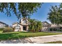 Inviting home featuring a well-kept lawn, mature trees, and a convenient two-car garage at 1201 Shelter Rock Rd, Orlando, FL 32835