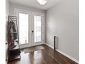 Bright foyer with wood flooring and glass paneled double doors with an ornamental coat rack at 1265 Blarney St, Minneola, FL 34715