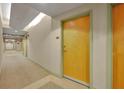 Condominium hallway with neutral walls and a vibrant yellow unit door at 155 S Court Ave # 1909, Orlando, FL 32801