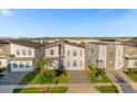 Aerial view of a modern community with two-story homes, green lawns, and a clear blue sky at 2927 Fable St, Kissimmee, FL 34746