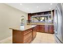 Stylish kitchen with granite countertops, a central island with drawer storage, and stainless steel refrigerator at 3217 Castle Oak Ave, Orlando, FL 32808