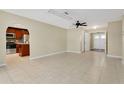 Open floor plan with neutral tile flooring connecting the living area to the kitchen with modern appliances at 3217 Castle Oak Ave, Orlando, FL 32808