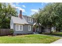 Well-maintained gray two-story home with a brick chimney, lush lawn, and beautiful landscaping at 338 E Anderson St, Orlando, FL 32801