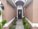 Inviting front entrance with a decorative door, covered porch, and well-maintained landscaping at 340 Haversham Way, Davenport, FL 33897