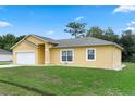 Well-maintained home showcasing neat landscaping, a spacious lawn, and a convenient two-car garage at 670 Cotulla Dr, Kissimmee, FL 34758