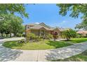 Beautiful home with lush landscaping, mature trees, and well-kept grounds on a sunny day at 7699 Milano Dr, Orlando, FL 32835