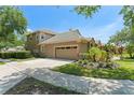 Two-story home featuring a two-car garage, concrete driveway, and manicured landscaping at 7699 Milano Dr, Orlando, FL 32835