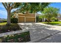 A two-story home with a three-car garage, driveway, and mature trees at 887 Lancer Cir, Ocoee, FL 34761