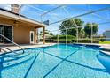 Beautiful screened-in pool with a waterfall feature, patio, and lush landscaping at 887 Lancer Cir, Ocoee, FL 34761