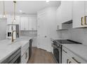 Modern, all-white kitchen with stainless steel appliances, marble countertops, and gold hardware at 9265 Eagles Perch Pl, Orlando, FL 32825