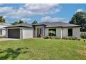 Charming single-story home with lush green lawn, stone accents, and a dark-colored two car garage at 934 Jessamy St, Oviedo, FL 32765
