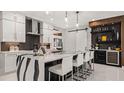 Modern kitchen showcasing waterfall island, sleek cabinetry, wine fridge, and contemporary lighting fixtures at 960 Club Cresswind Dr, Lady Lake, FL 32159