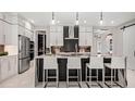 Elegant kitchen featuring a waterfall island, sleek white cabinetry, and stainless steel appliances at 960 Club Cresswind Dr, Lady Lake, FL 32159