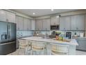 Bright kitchen with modern gray cabinets, stainless appliances, and large island at 1217 Reunion Village Blvd, Kissimmee, FL 34746