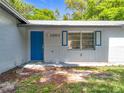 Close-up view of the house entrance, highlighting a bright blue door and freshly painted facade at 1307 Jean Ct, Eustis, FL 32726