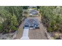 An aerial view showcases a modern home with expansive lot, a long driveway, and lush surrounding greenery at 13419 Sw 77Th Ave, Ocala, FL 34473