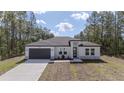 Stunning single-story home with a modern white exterior, two car garage, and well-maintained lawn at 13419 Sw 77Th Ave, Ocala, FL 34473
